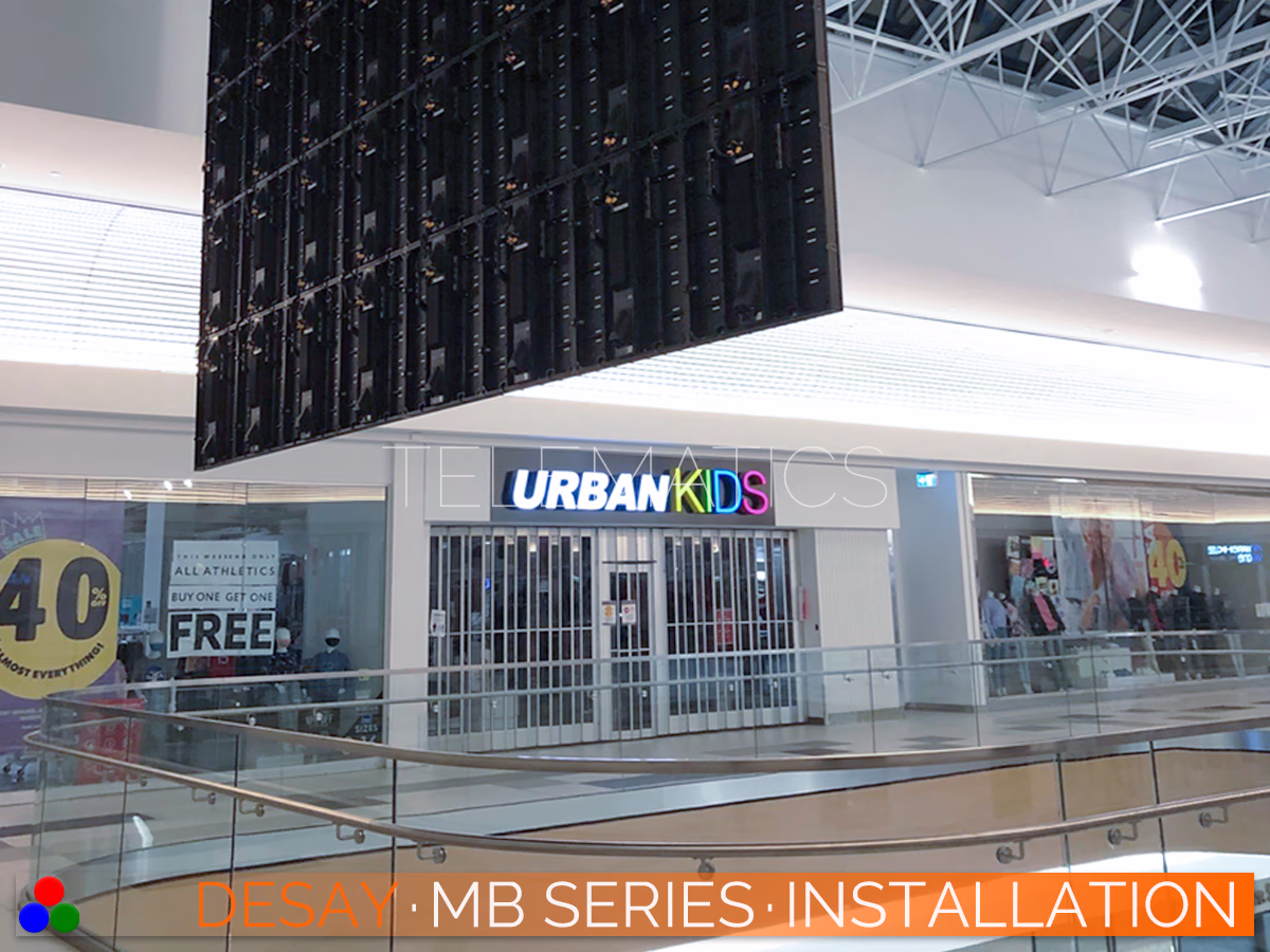 The Art Of LED · Desay MB Series · Telematics Canada nderside rear view of a hanging Desay MB Series installation in a commercial center, demonstrating the secure rigging and slim profile of the cabinets.