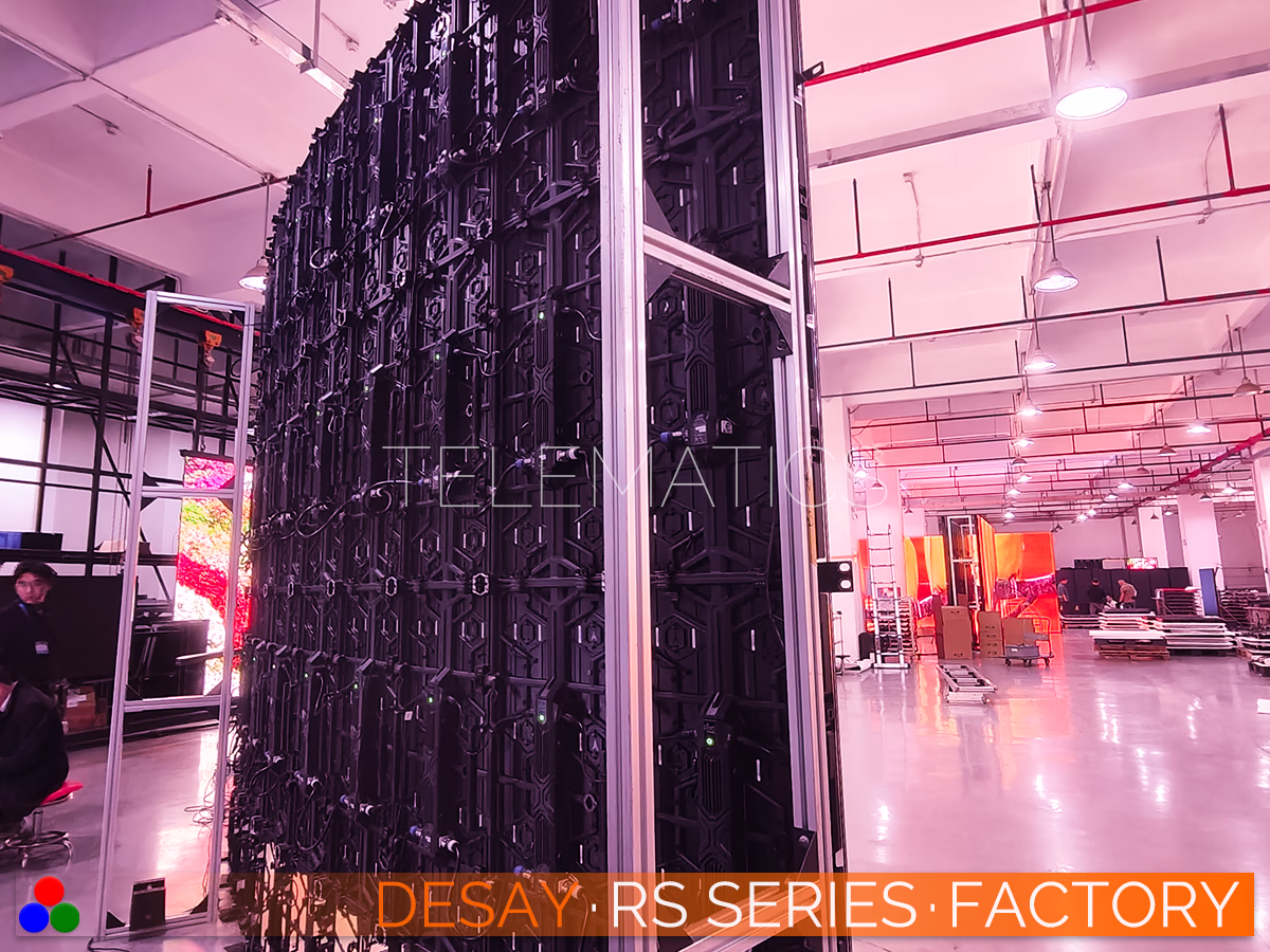 The Art Of LED · Desay RS Series · Telematics Canada Vertical structural assembly of a curved LED tower in the Desay factory, showcasing the rear support frame and cabling architecture for high-rise rental configurations.